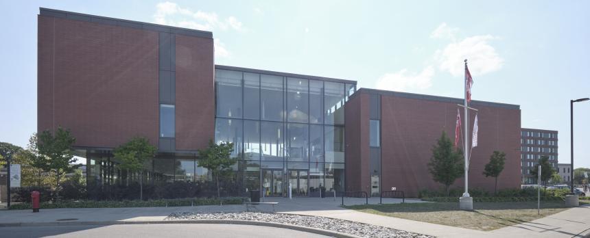 The outside of the academic centre building, showing the glass atrium wall.
