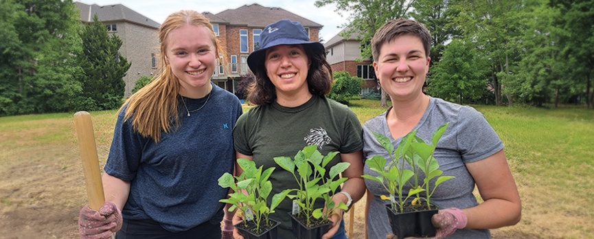 Three students work in the Tiny Home Takeout Garden