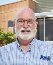 Fr. Gregory Boyle standing in front of the entrance at Homeboy Industries